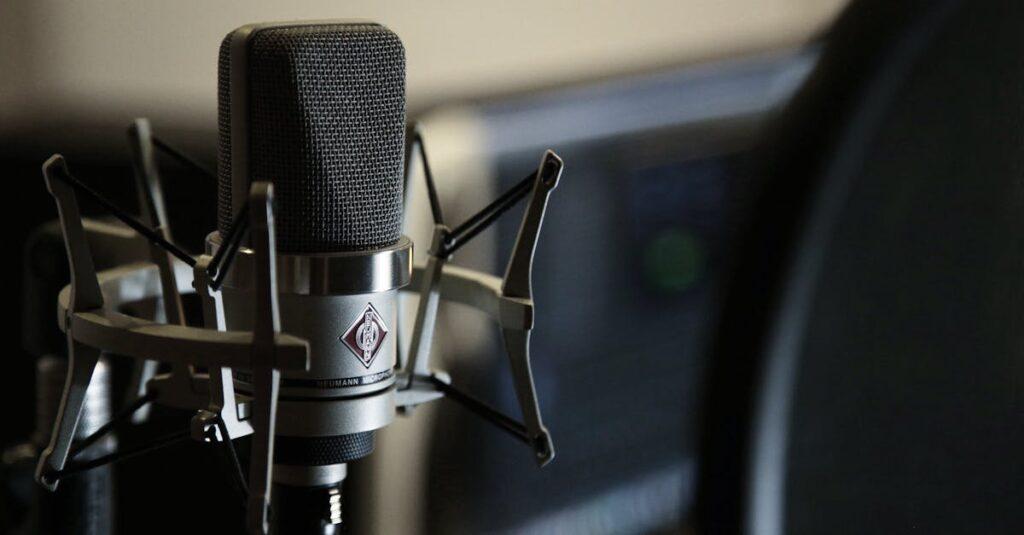 Detailed view of a condenser microphone in a recording studio setting.